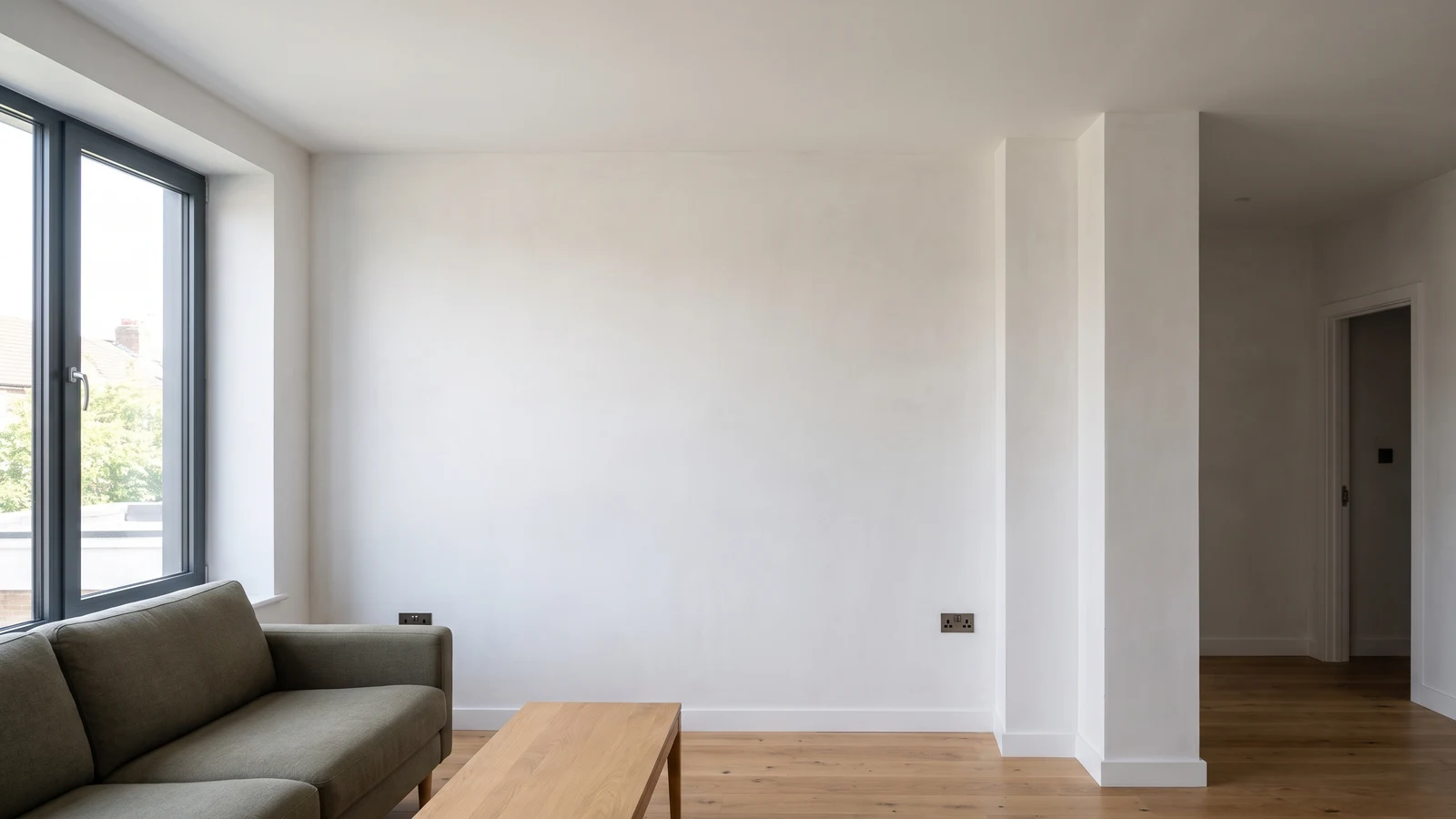Illustrative living room after plastering, with smooth finished walls